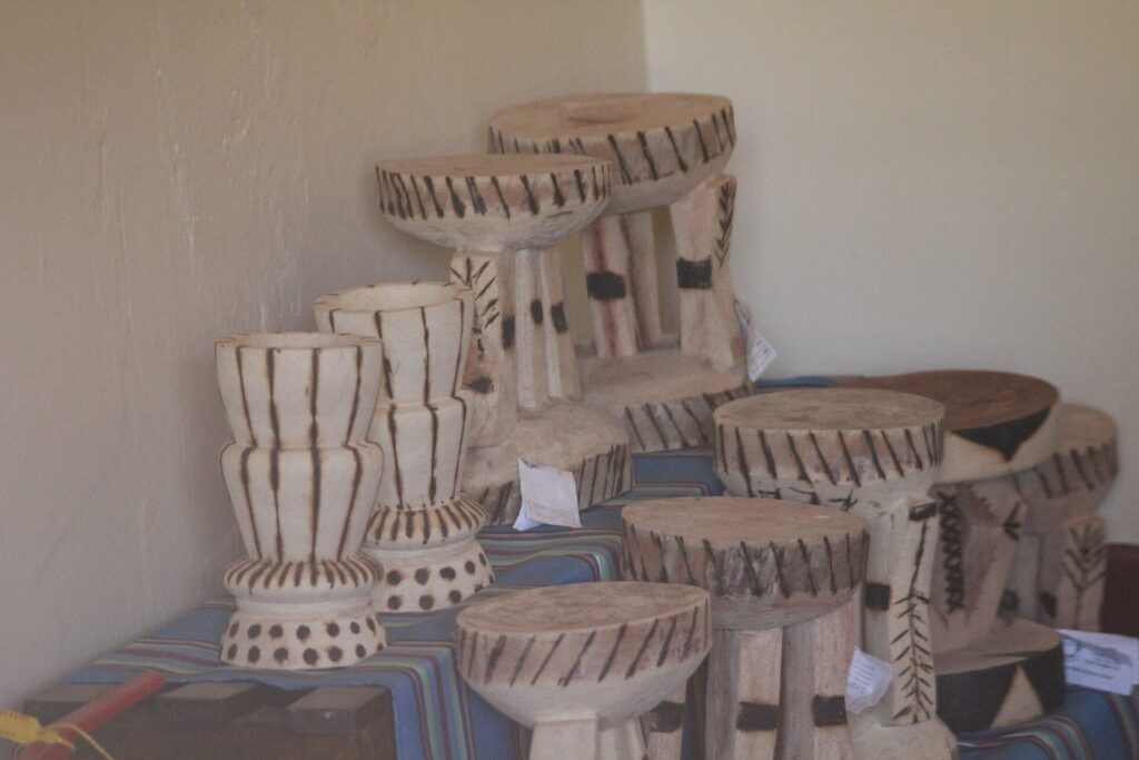 Tabouret bas en bois pos&eacute; sur un parquet dans une pi&egrave;ce d&eacute;pouill&eacute;e