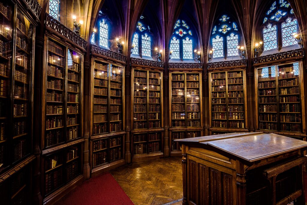 Salle de lecture d'une biblioth&egrave;que, longues tables de bois et lampes allum&eacute;es