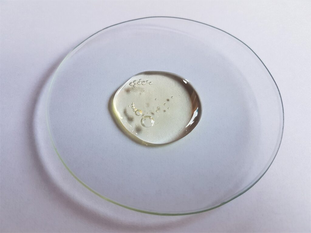 Brosse à dents rangée dans un verre sur le rebord d'un lavabo blanc