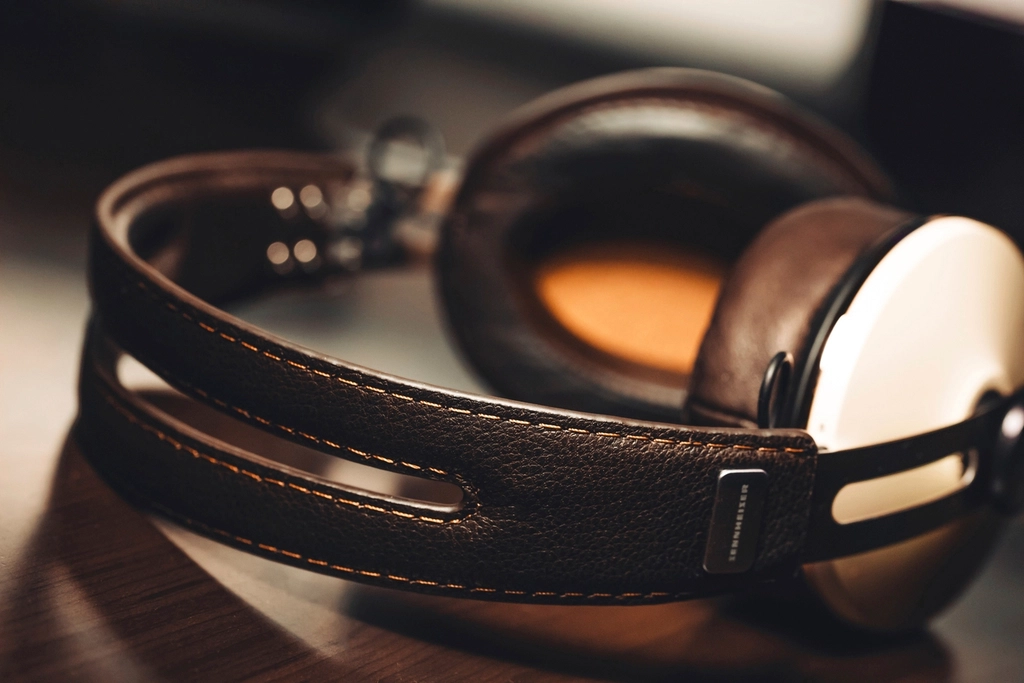 Casque audio pos&eacute; sur une table en bois, c&acirc;ble enroul&eacute; &agrave; c&ocirc;t&eacute; d'un carnet