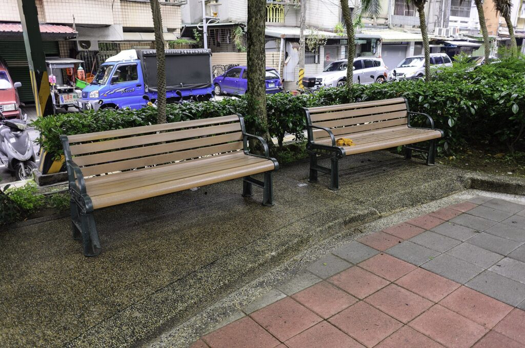 Banc de bois vide au bord d'une all&eacute;e bord&eacute;e d'arbres en fin de journ&eacute;e