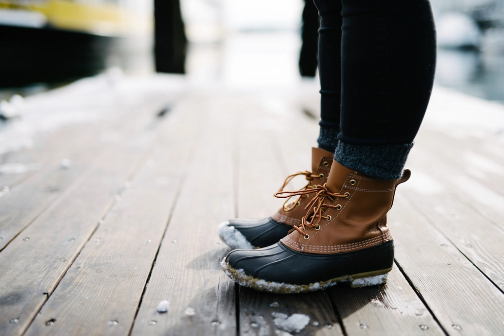 Veste r&eacute;fl&eacute;chissante et chaussures de marche pos&eacute;es pr&egrave;s d'une porte d'entr&eacute;e